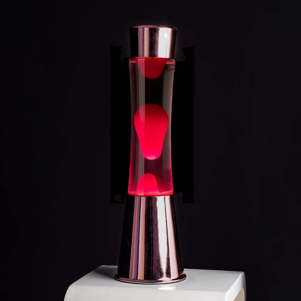 FISURA - Lavalampe rosa. Roségoldfarbener Chromsockel, transparente Flüssigkeit und rosa Lava. Lavalampe mit Ersatzbirne. Maße: 11 x 11 x 39,5 Zentimeter.