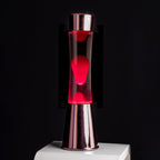 FISURA - Lavalampe rosa. Roségoldfarbener Chromsockel, transparente Flüssigkeit und rosa Lava. Lavalampe mit Ersatzbirne. Maße: 11 x 11 x 39,5 Zentimeter.
